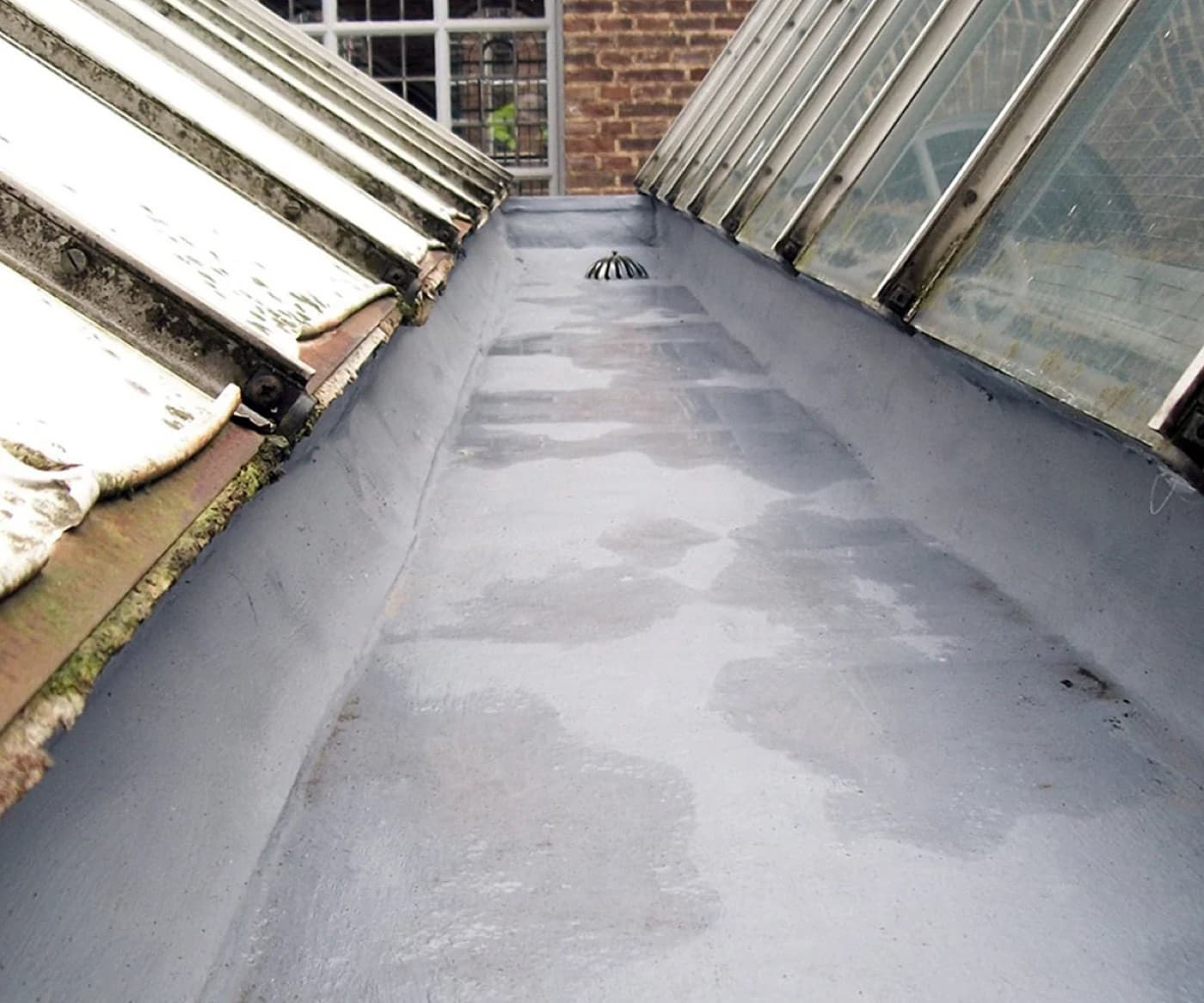 Cold liquid roof membrane applied over an existing mill roof